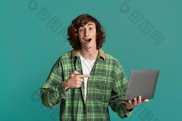 彩票中奖者。时髦的少年指着笔记本电脑，在彩色背景上大喊“天哪！”