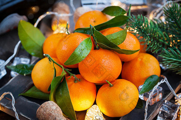 节日理念：新鲜的橘子、软木塞、玻璃杯、香槟、蜡烛和花环