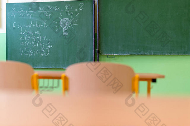 空荡荡的数学教室，有课桌、椅子和黑板。教育理念。