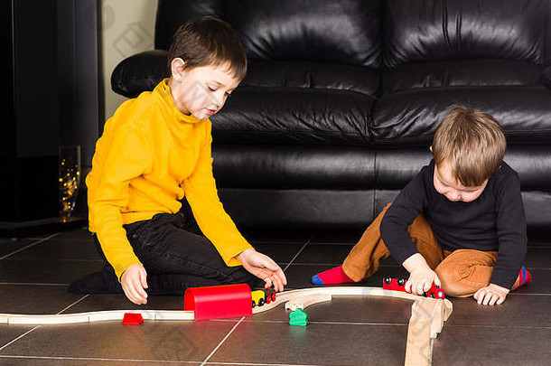 孩子们玩木玩具火车兄弟构建木铁路首页