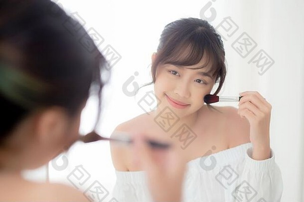 美肖像年轻的亚洲女人微笑脸镜子应用化妆刷脸颊卧室美丽的女孩持有脸红的人