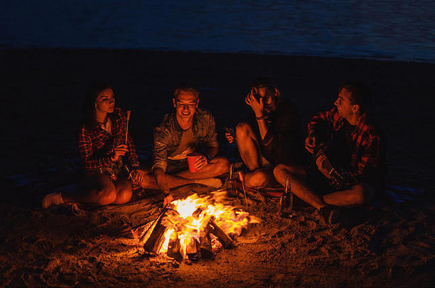 年轻的朋友们在海滩上用篝火野餐