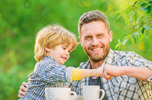 父亲一天朋友父亲儿子有趣的喂养儿子自然食物健康的食物父亲男孩喝茶在户外开发健康的吃习惯饲料婴儿自然营养概念