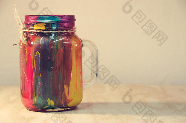 一个彩色水晶瓶的照片，瓶内有滴落的油漆