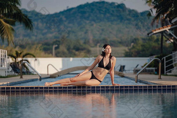 暑假在豪华酒店，女人在美丽的游泳池附近放松。美容美体中心。后视图，无面