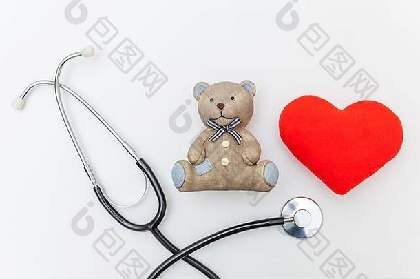 简单的最小设计玩具熊红心和医疗设备听诊器隔离在白色背景。保健儿童医生的概念。儿科医生符号。平面俯视图空间