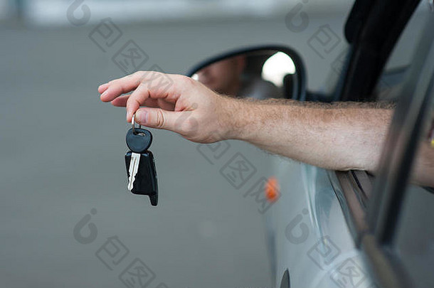 男人的手持有关键车象征着快乐购买运输发放贷款开车