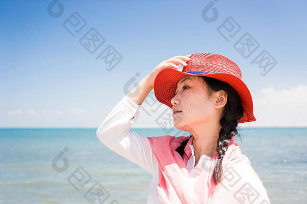 海边戴红帽的亚洲女人