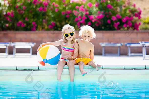 孩子们在室外游泳池玩耍。小女孩和小男孩在热带海滩岛的度假泳池里玩耍和游泳。游泳和眼睛