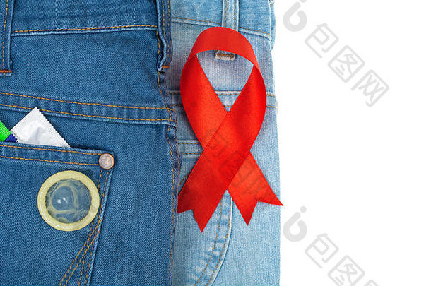 蓝色牛仔裤背景上的红丝带和避孕套。认识和保护艾滋病、艾滋病毒的概念。12月1日