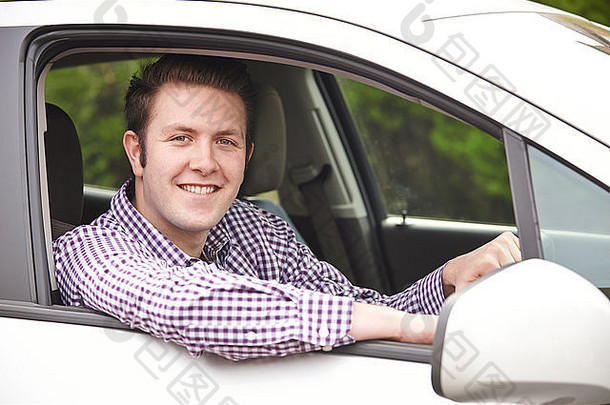 从车窗向外看的年轻男司机的画像