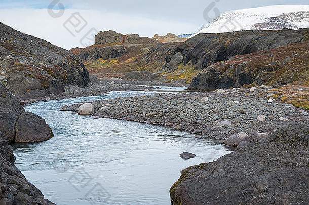 北极地区夏秋季节的一条河流，有五颜六色的植被