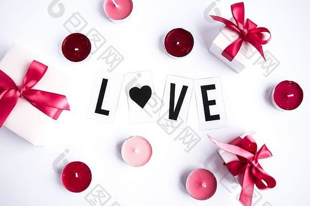 白色桌面背景上的爱情文字，带有礼品盒和蜡烛
