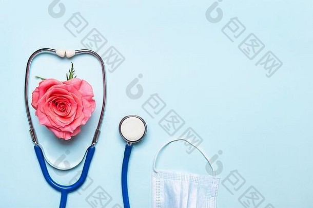 粉红色的玫瑰心听诊器保护面具蓝色的背景医生护士一天概念