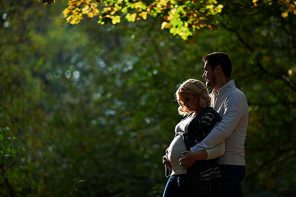 丈夫和怀孕的妻子正在公园里散步