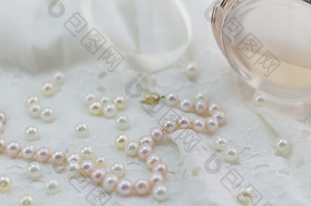 珍珠<strong>背景</strong>分散珍珠粉红色的珍珠<strong>项链</strong>散焦白色花边香水瓶