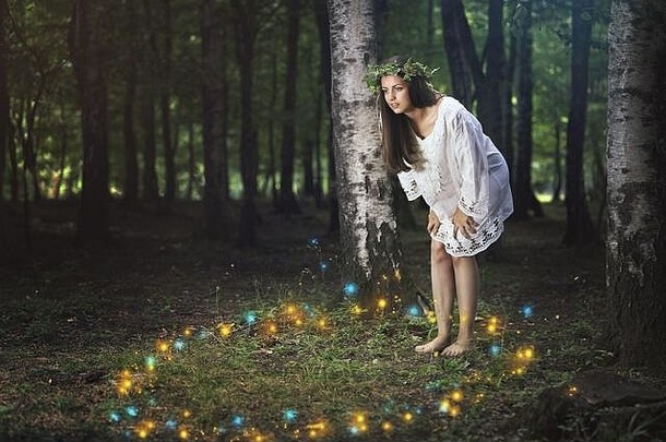 美丽的女孩凝视着森林精灵的舞蹈。幻想与童话