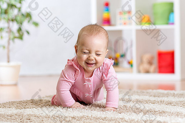 快乐有趣的婴儿在家里爬在室内