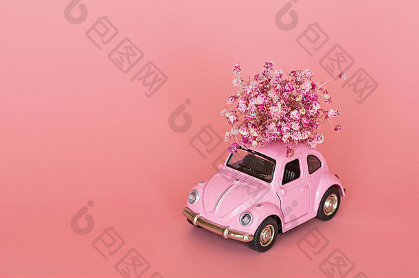 粉色复古玩具车，在粉色背景上传递花束。情人节，2月14日。3月8日国际妇女节，母亲节