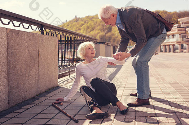 有礼貌的老人帮助一位女士起床
