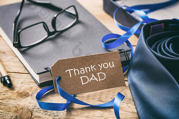 父亲节的概念。蓝色领带，谢谢爸爸写在标签上，办公桌背景
