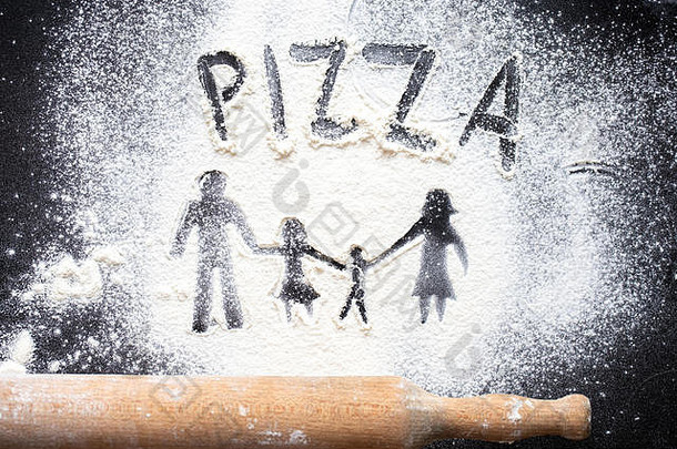 在一张黑色的桌子上，以家庭<strong>人物</strong>的形式<strong>展示</strong>面粉。做比萨饼。家庭休闲的概念。