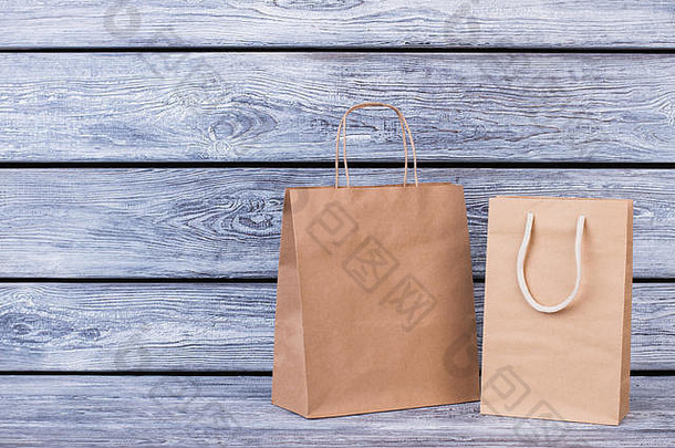 木质背景上的棕色纸购物袋。