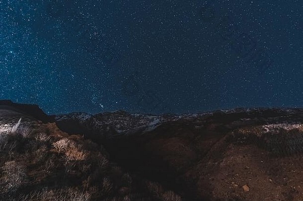 在马拉喀什、艾特·本·哈杜和瓦扎扎特之间的阿特拉斯山脉，摩洛哥上空的夜空中有银河和星星。雪