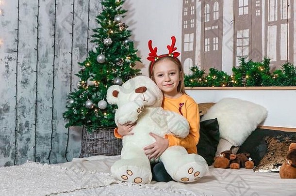 小女孩在圣诞照片上拥抱小熊