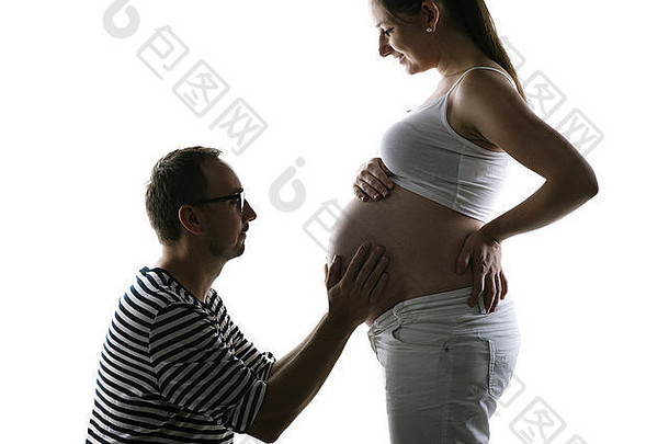 轮廓年轻的怀孕了夫妇摆姿势工作室孤立的白色背景