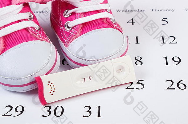 怀孕测试积极的结果婴儿鞋子说谎日历概念扩展家庭期待婴儿
