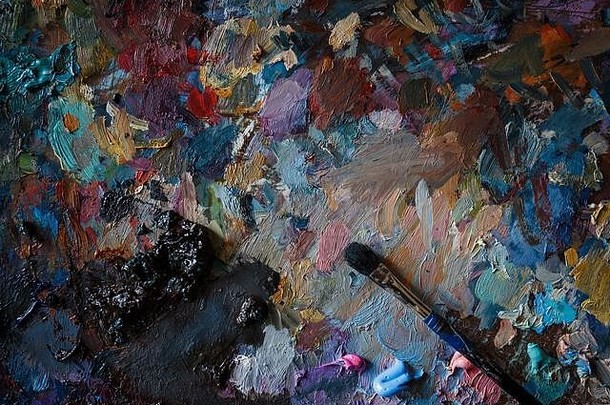 艺术家的调色板，带有多色涂抹颜色和一支画笔。闭合。