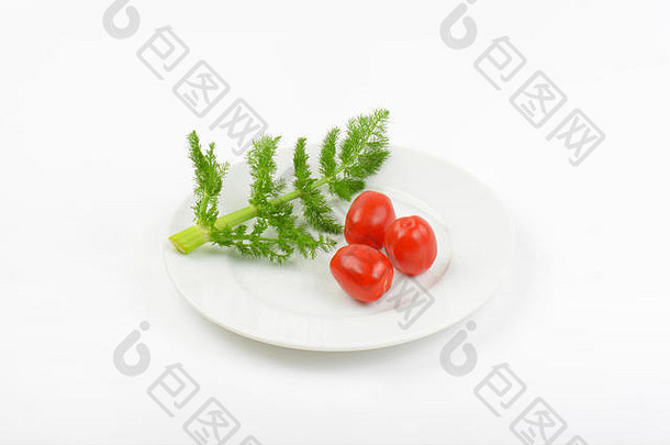 白色盘子上的莳萝枝和樱桃番茄
