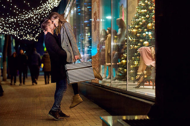 一对带着包裹的年轻夫妇在圣诞节购物。
