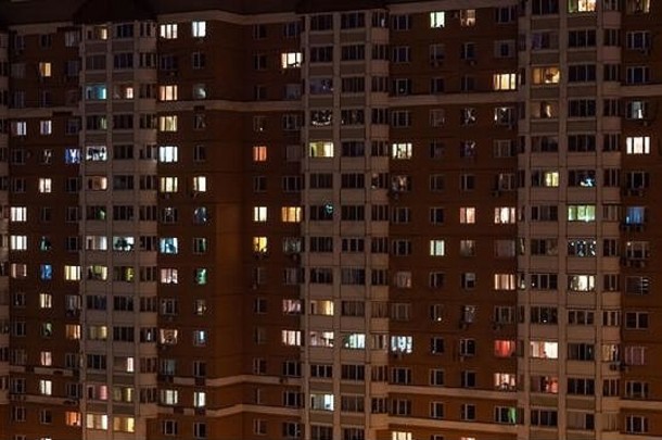 夜间带有发光窗户的生活公寓楼立面视图