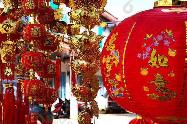 中国新年红纸灯笼的传统装饰，带有金色象形文字和金鱼特写