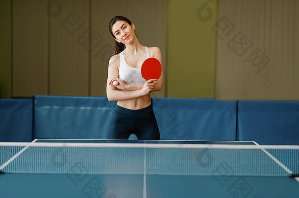 桌旁拿着<strong>乒乓球</strong>拍的年轻女子