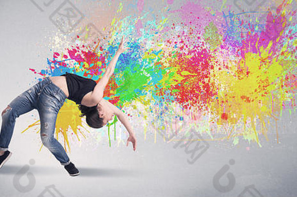一个时髦的当代嘻哈舞者在灰色背景前跳舞，彩色明亮的油漆飞溅概念
