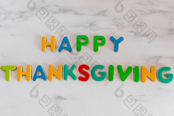 在大理石背景上用彩色字母书写的<strong>感恩节</strong>快乐词，俯视图
