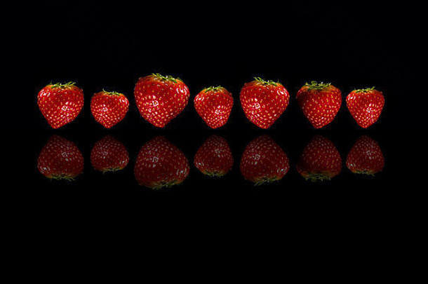 草莓反映了黑色的背景