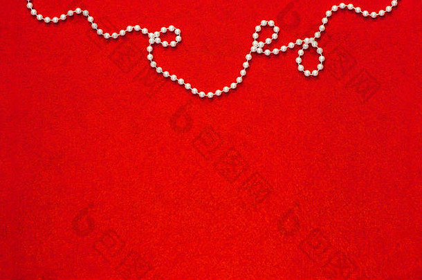 鲜亮的红色毛毡背景，顶部边框为白色珠状球体链