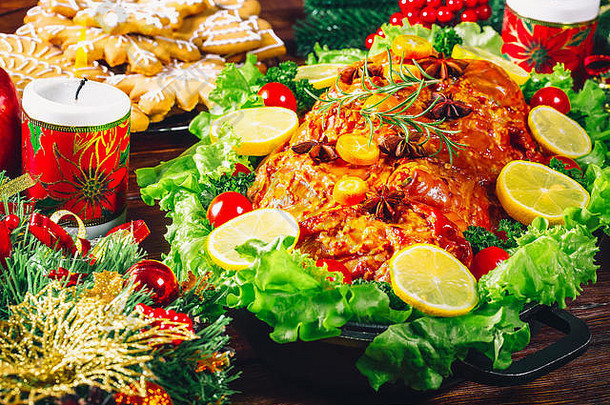 圣诞餐桌晚餐时间，烤肉，蜡烛和新年装饰。背景感恩节。家庭度假的概念，美丽的德