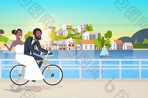 刚结婚的男人女人骑自行车浪漫的非裔美国人夫妇新娘新郎骑自行车享受快乐的婚礼日概念山城市岛