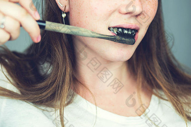 年轻的女人刷牙牙齿黑色的牙粘贴活跃的木炭黑色的牙刷白色背景牙齿美白