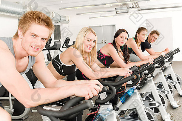 健身组的人骑自行车在健身房里旋转