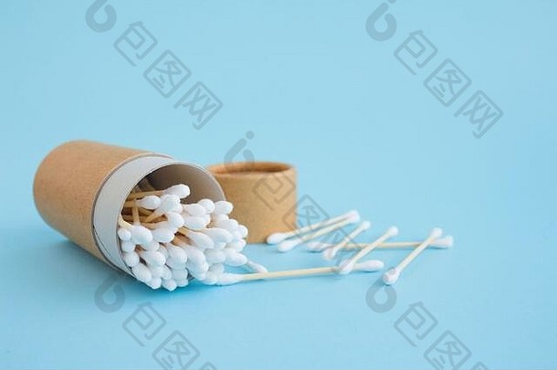 蓝色背景下，竹棉棒装在可重复使用的纸包装管中。为您的设计提供拷贝空间，零浪费概念