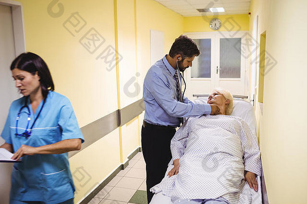 医生在走廊检查老年病人