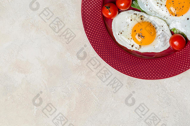 边界和自由空间，两个煎蛋早餐，沙拉罗马诺和樱桃西红柿，从右边缘的红色盘子。水平自由空间