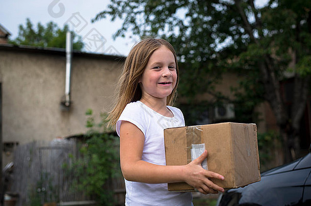 13岁以下的女孩长金发碧眼的头发携带纸箱盒子微笑