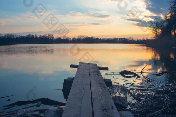 跳板海岸湖设置太阳美丽的idylic场景日落湖云树镜像水表面